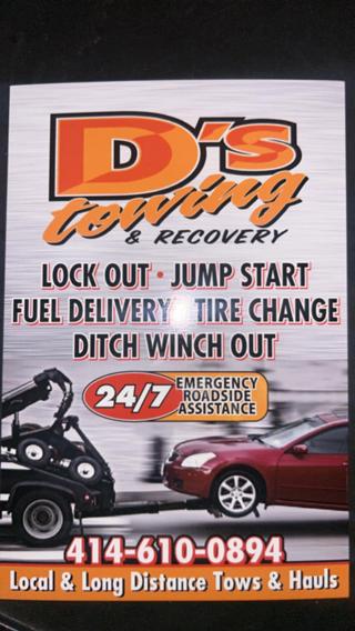 D's Towing services sign: lock out, jump start, fuel delivery, tire change, ditch winch out, 24/7 emergency roadside assistance, 414-610-0894